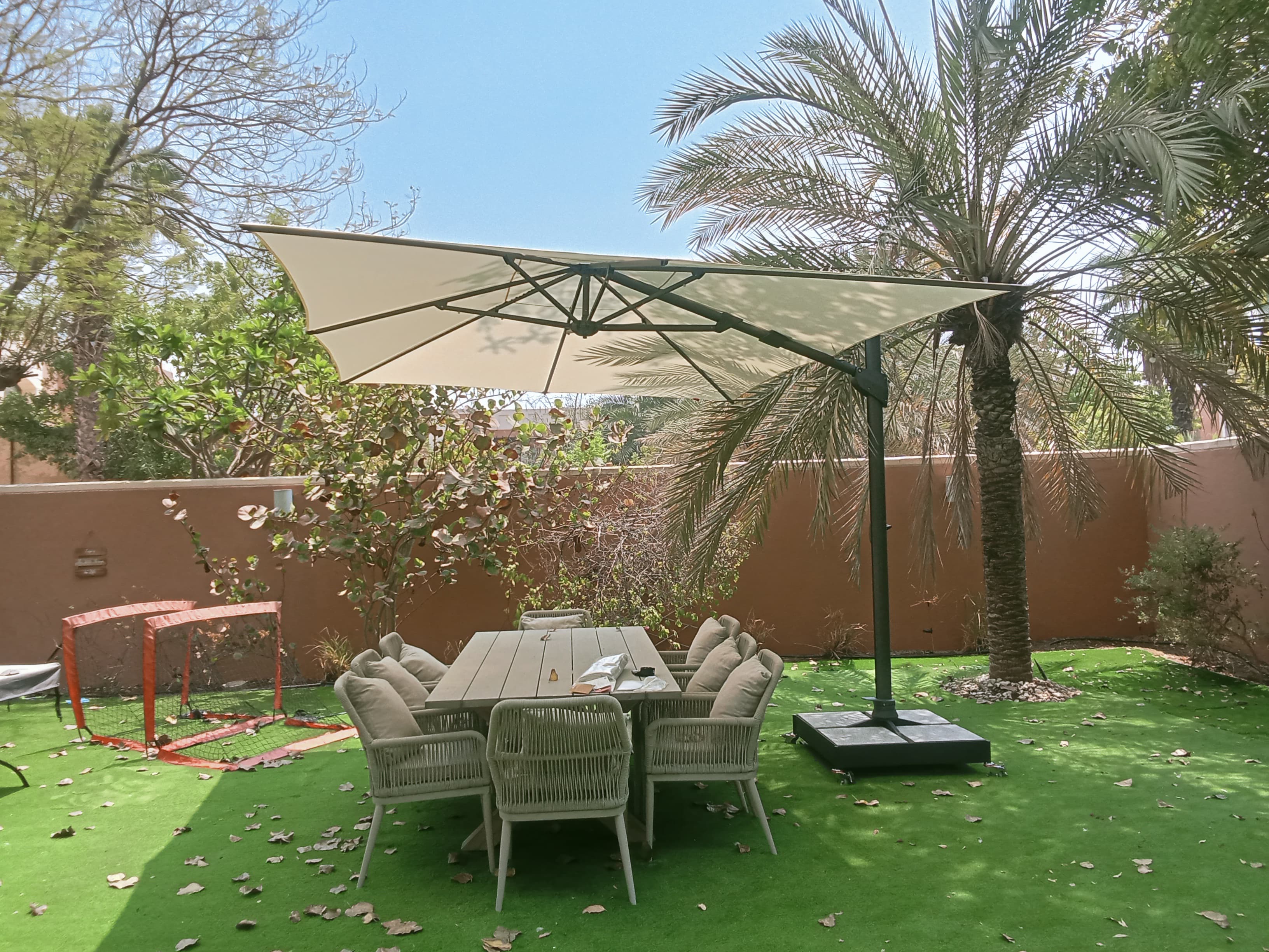 Fortano cantilever umbrella shading an outdoor dining table in an Abu Dhabi garden
