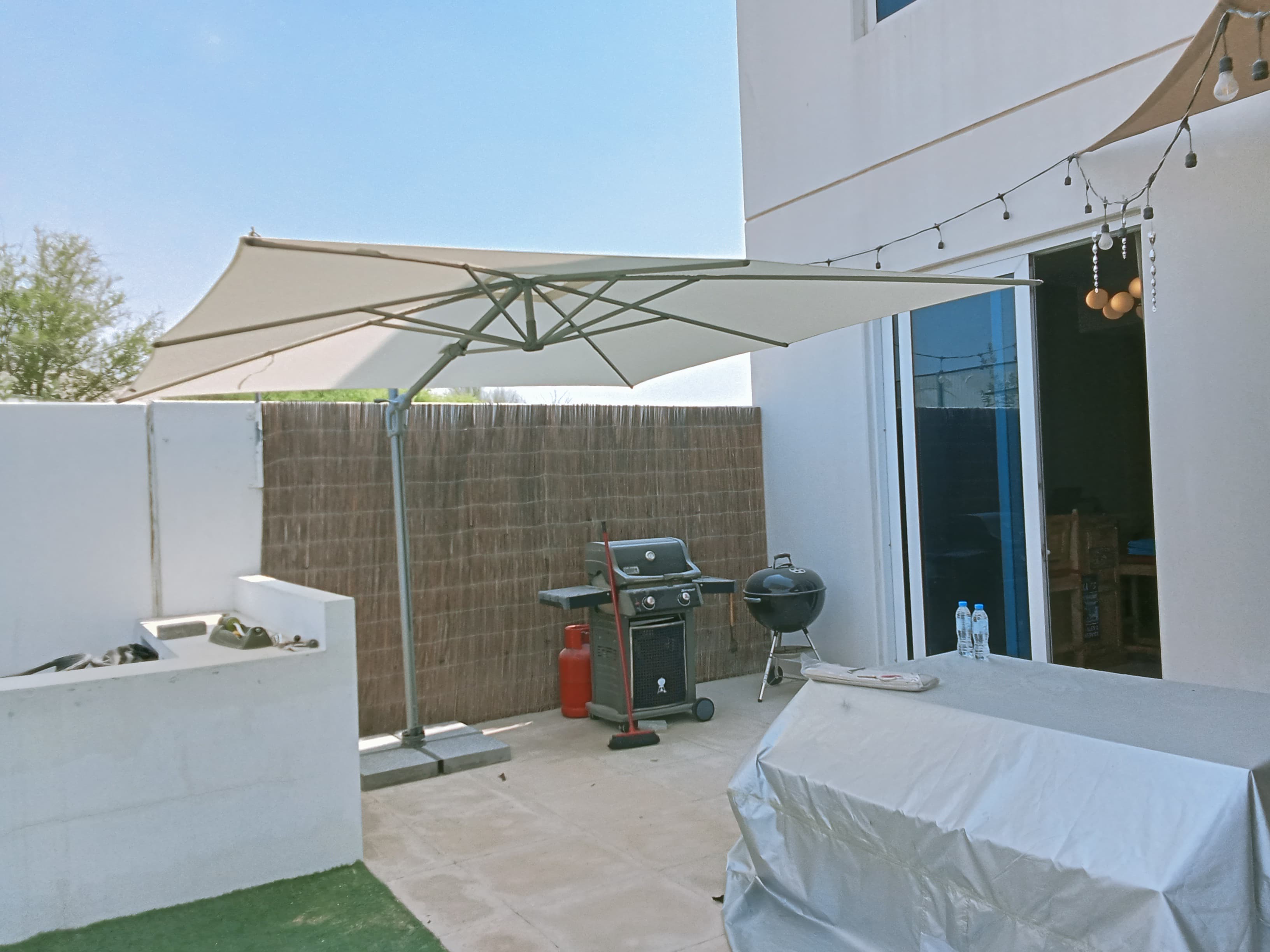 Close view of Sunflex umbrella canopy and base installed on a patio in Nad Al Sheba